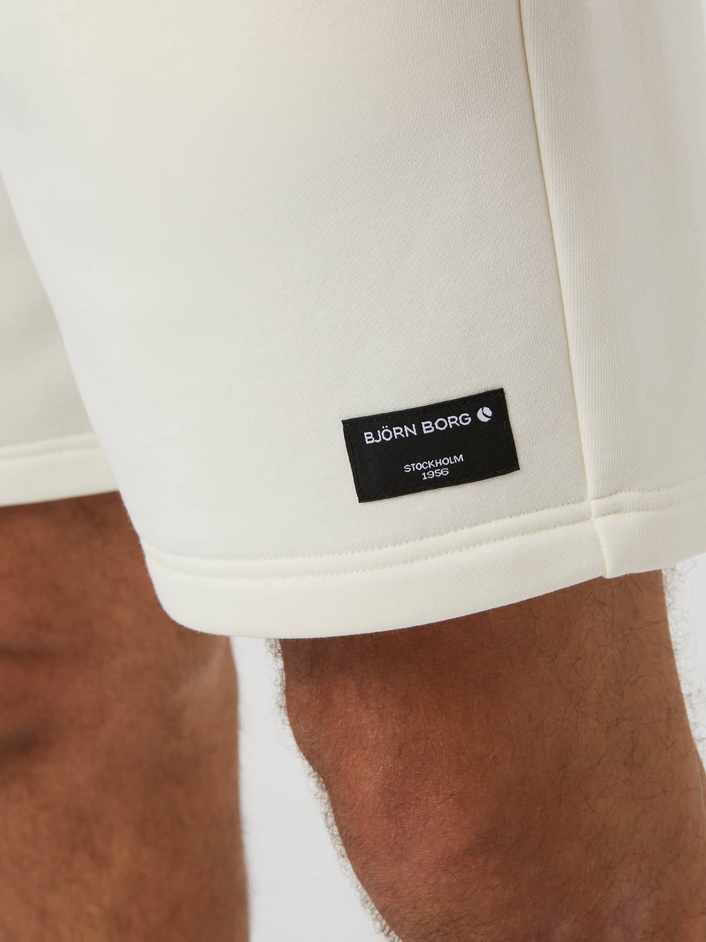 Närbild på Björn Borg Centre Sweatshorts för herr i Egret (Vit) med en stilren svart logoetikett på benet. - Image 4