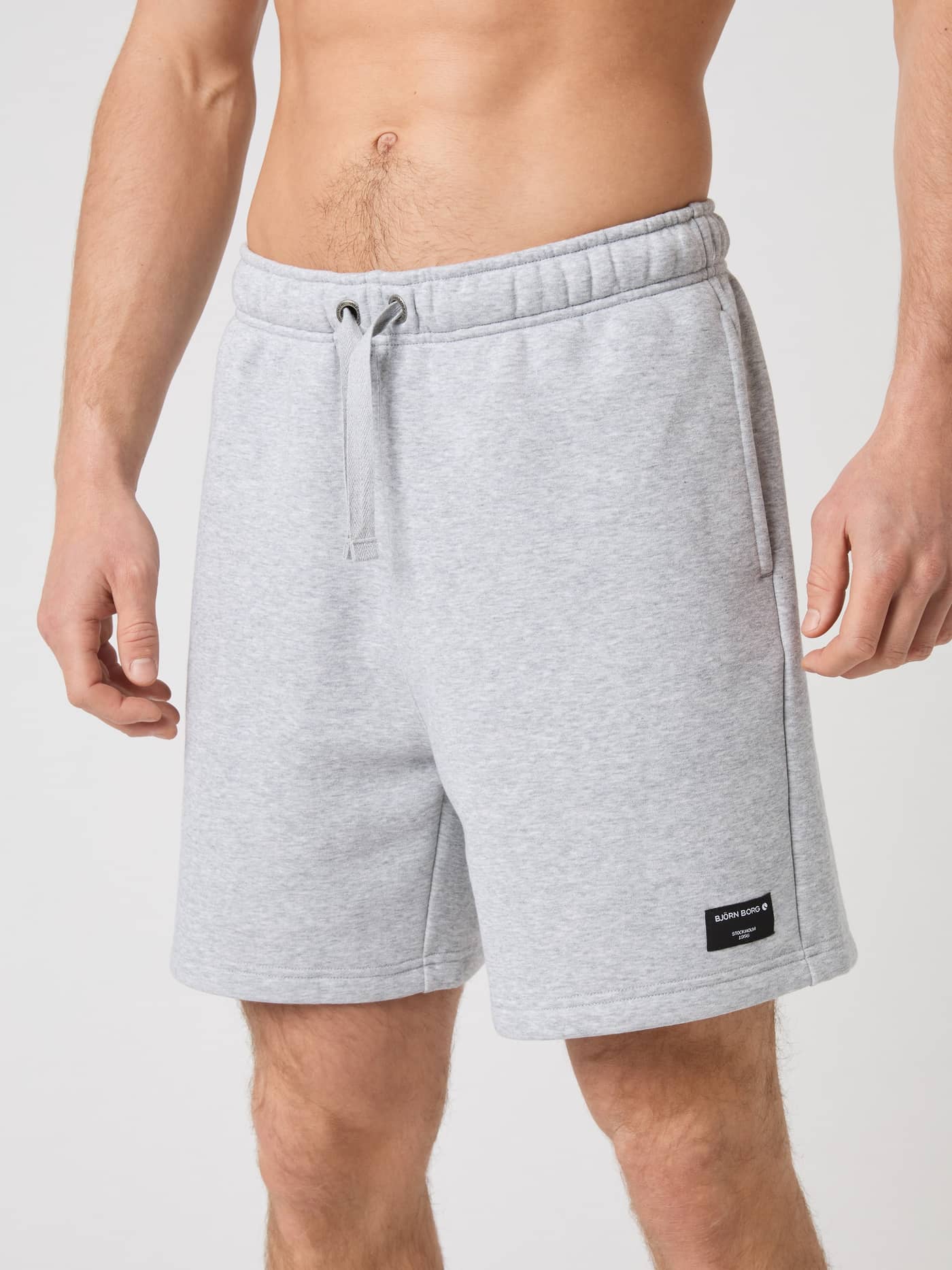 Vue de face d'un homme portant le Centre Sweatshorts en Light Grey Melange (Gris), coupe régulière, style et fonction. - Image 1