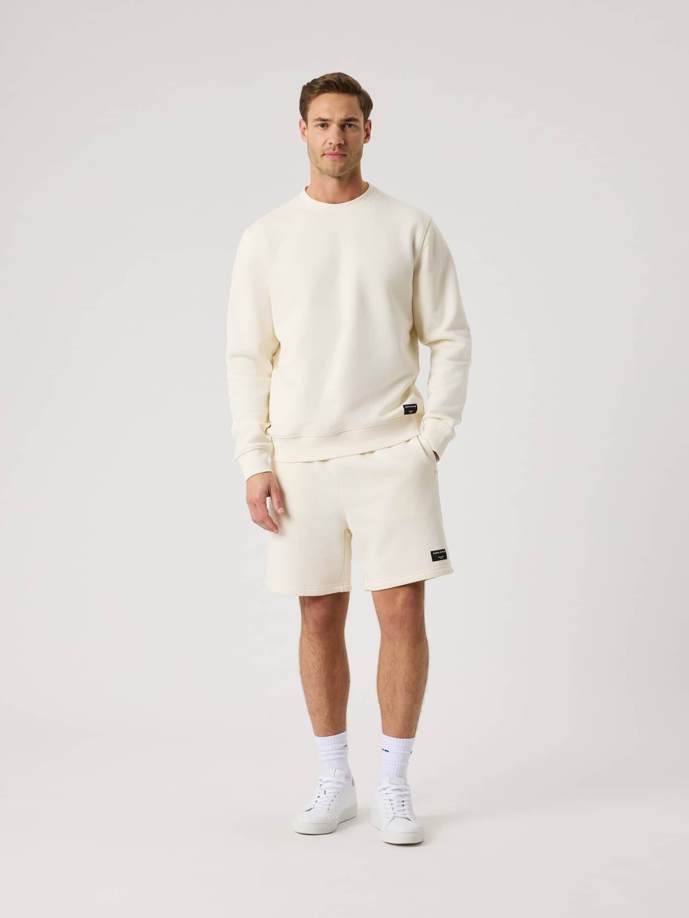 Full-body front view of a man wearing the Björn Borg Centre Sweatshorts in Tofu (White) for a stylish leisure look. - Image 3