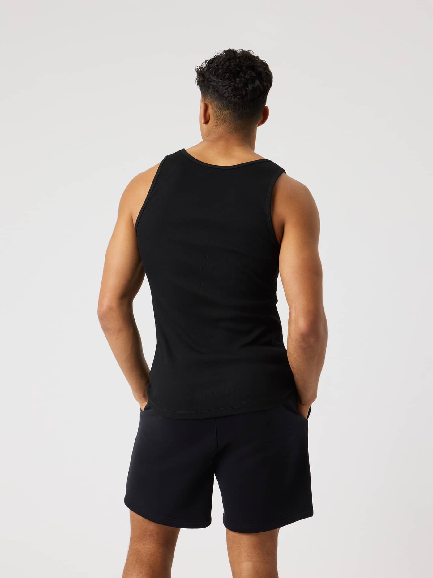 Back view of a man wearing the slim fit Björn Borg Centre Ribbed Tank in Black Beauty (Black) with a soft ribbed texture. - Image 2