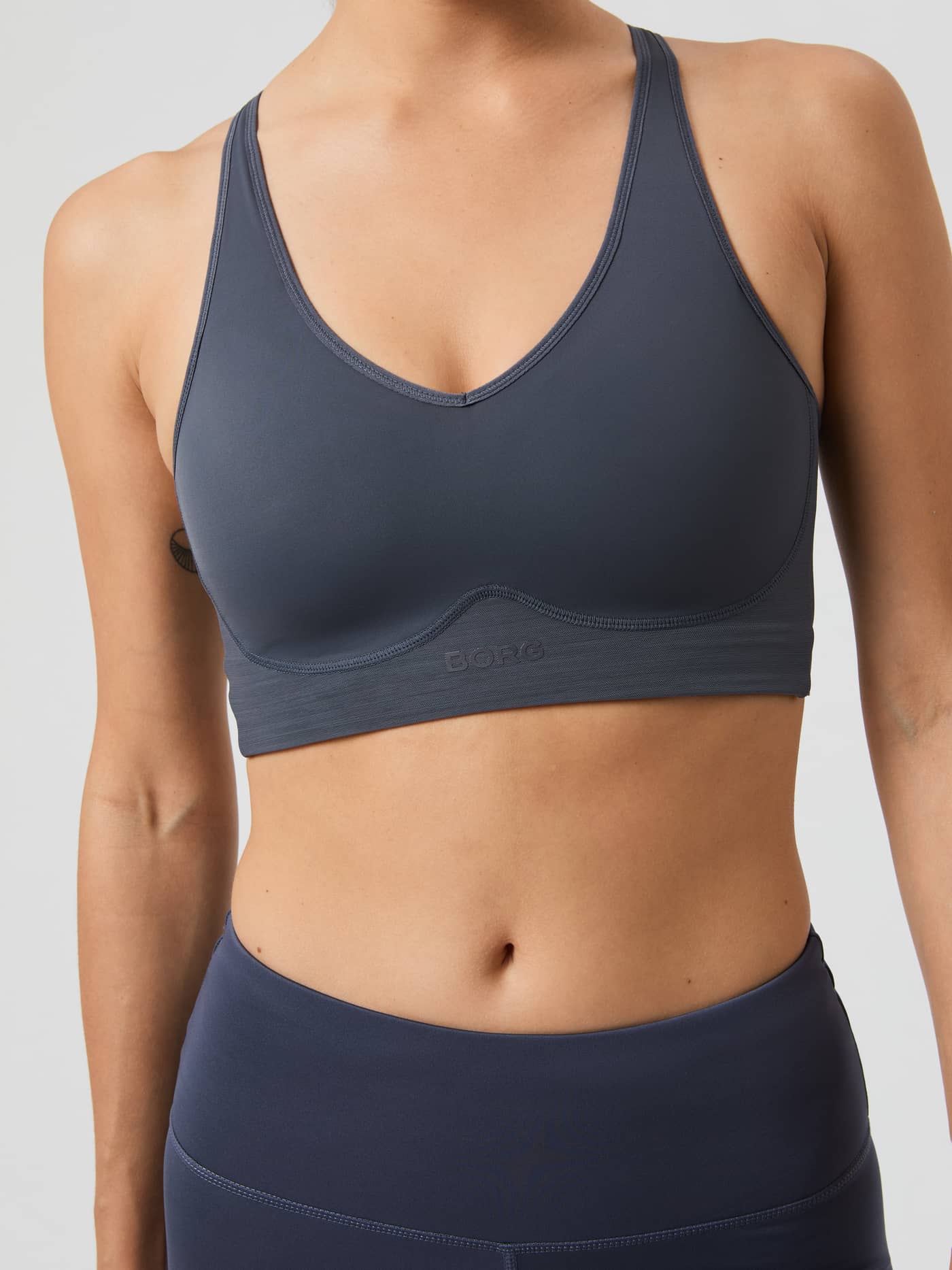 Vue de face du Borg Mid V Support Sports Bra Odyssey Gray (Gris) pour l'entraînement, avec logo tonal et col en V. - Image 5