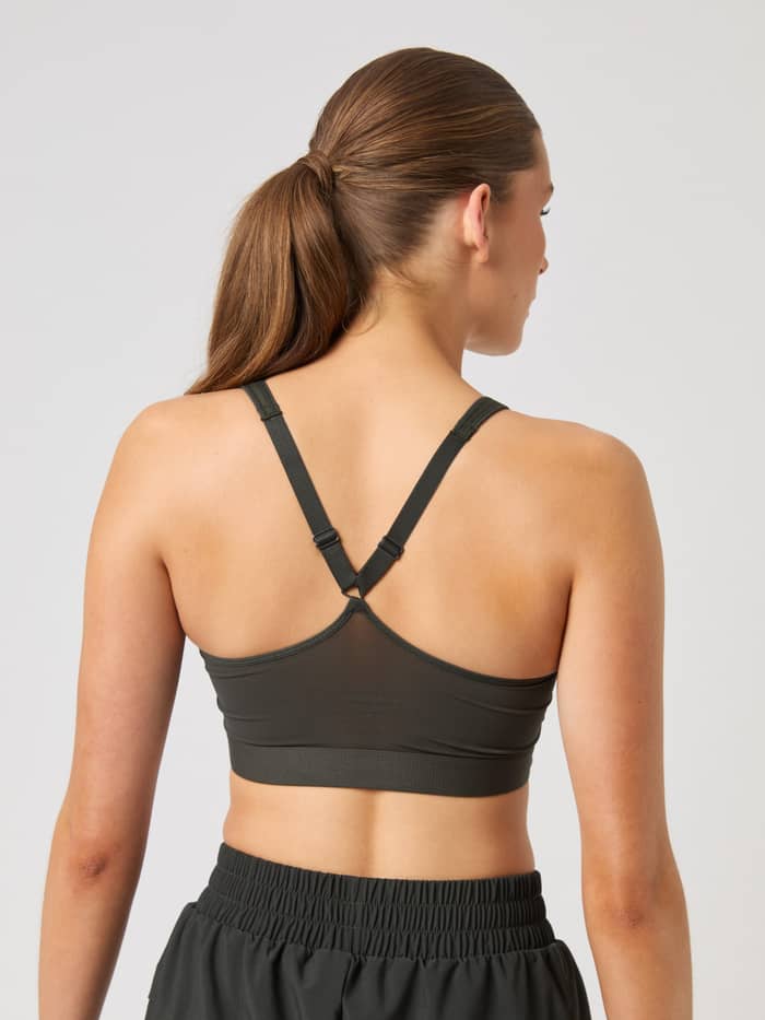 Borg Mid V Support Sports Bra i Peat (Grön) sedd bakifrån på en modell för träning, med en meshpanel på ryggen. - Image 4