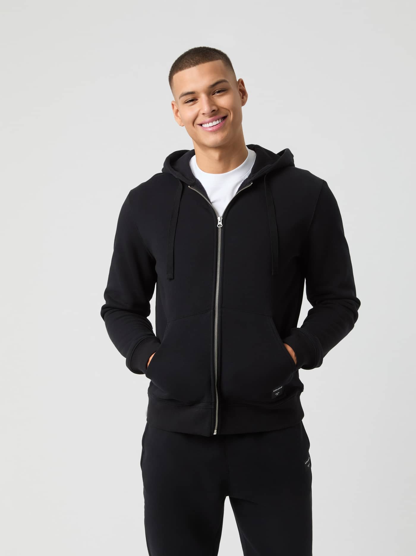 Front view of a man wearing the Björn Borg Centre Zip Hoodie in Black Beauty (Black) with a functional zip-up front. - Image 1