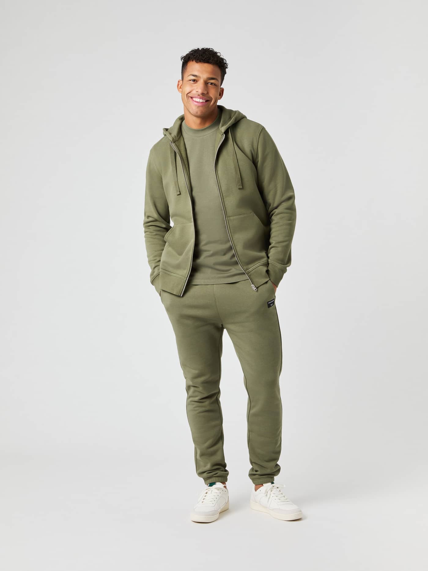 Ganzkörperansicht eines Modells im Björn Borg Centre Zip Hoodie in Dusty Olive (Grün) mit funktionalen Vordertaschen. - Image 3