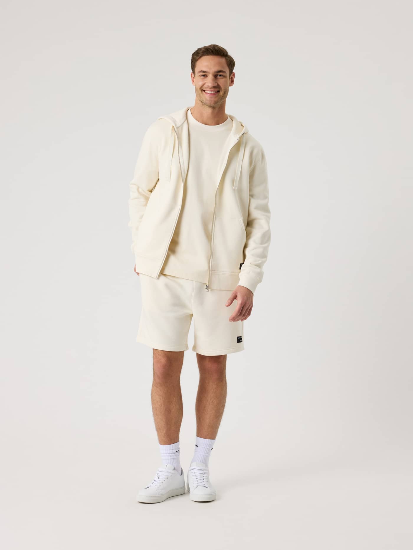 Centre Zip Hoodie i Tofu (Hvid) vist i fuld figur med sort logo og lynlås i en stilfuld pasform til mænd. - Image 3