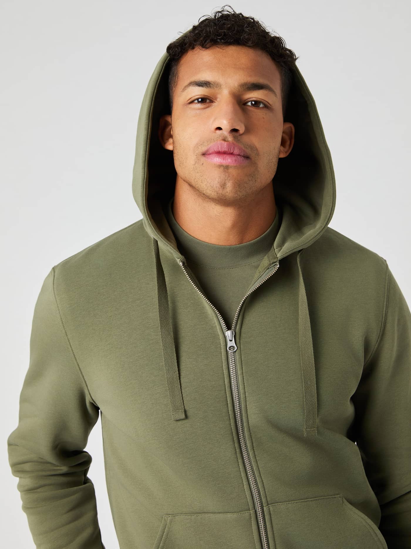 Vorderansicht eines Mannes im Björn Borg Centre Zip Hoodie in Dusty Olive (Grün) mit durchgehendem Reißverschluss und Kapuze. - Image 4