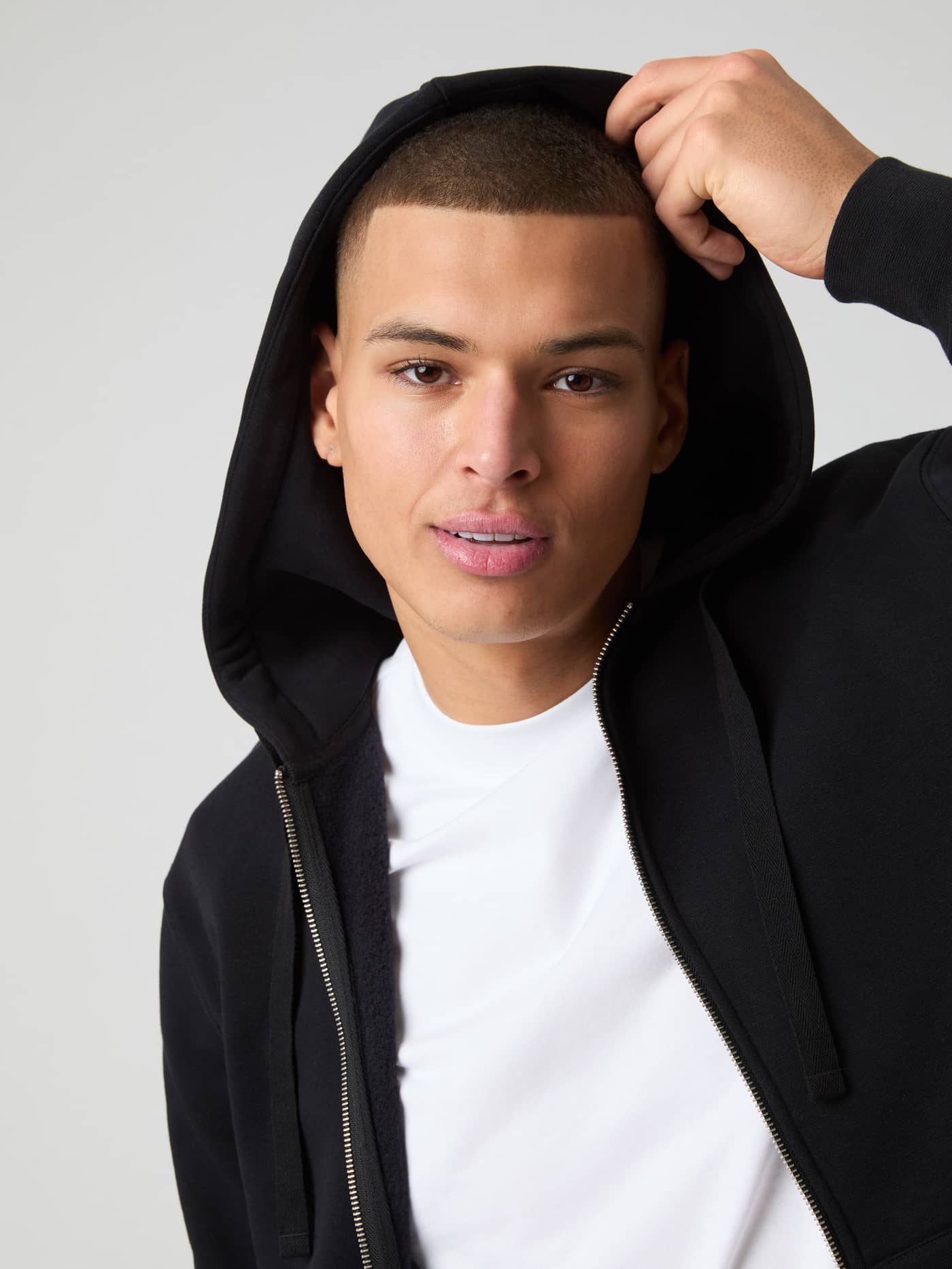 Björn Borg Centre Zip Hoodie in Black Beauty (Zwart) gedragen door een man met de capuchon op in close-up. - Image 5