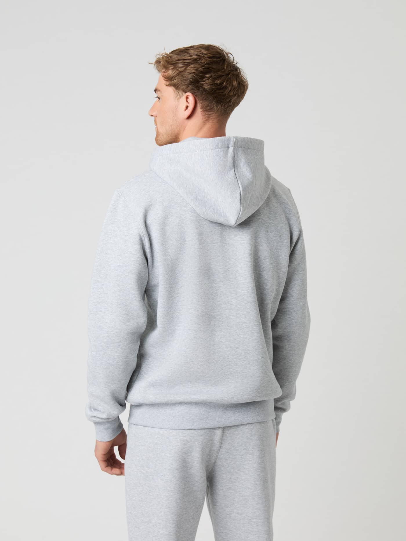 Back view of a man wearing the stylish Björn Borg Centre Zip Hoodie in Light Grey Melange (Grey). - Image 4