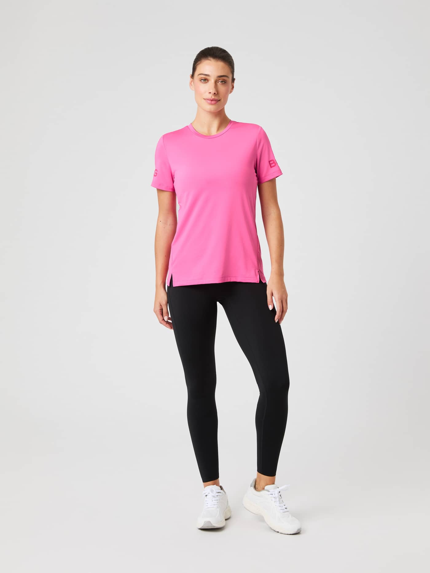 Borg T-Shirt i Ibis Rose (Rosa) för dam sedd framifrån med svarta träningsleggings och vita sneakers för träning. - Image 3