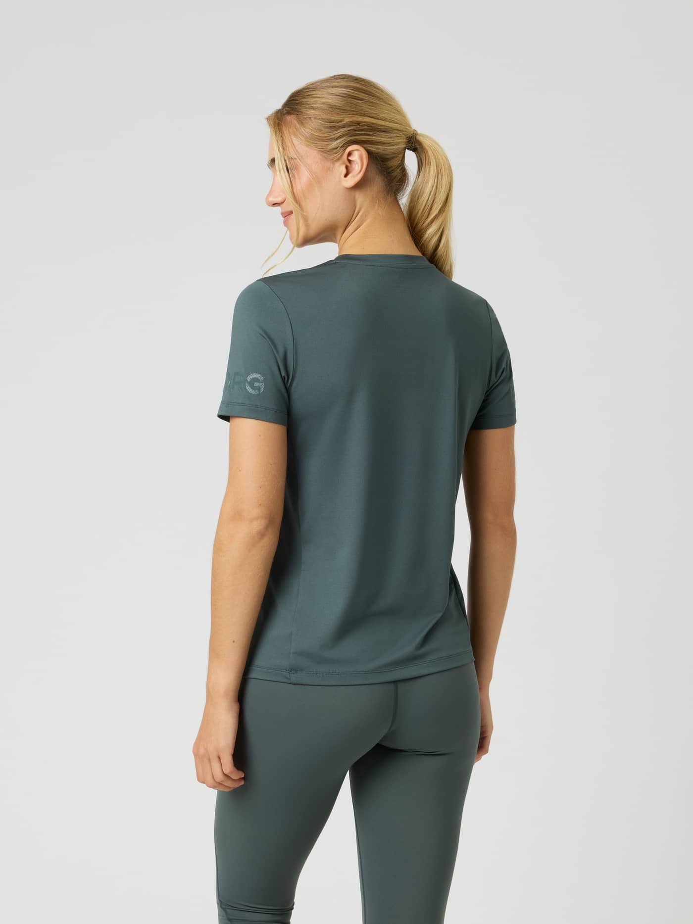 Back view of a woman wearing the Borg T-Shirt in Urban Chic (Green) featuring sleeve logo prints for training. - Image 2