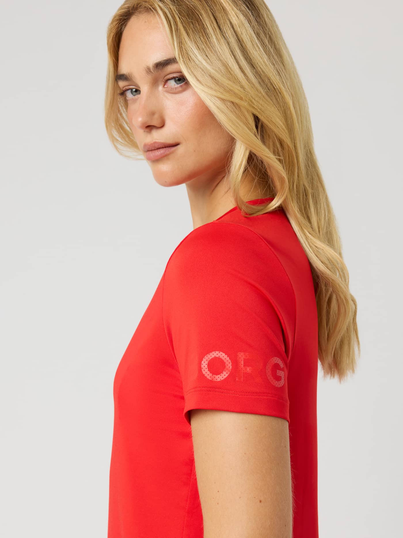 Side view of the women's Borg T-Shirt in Flame Scarlet (Red) performance fabric with a tonal logo for training and tennis. - Image 5