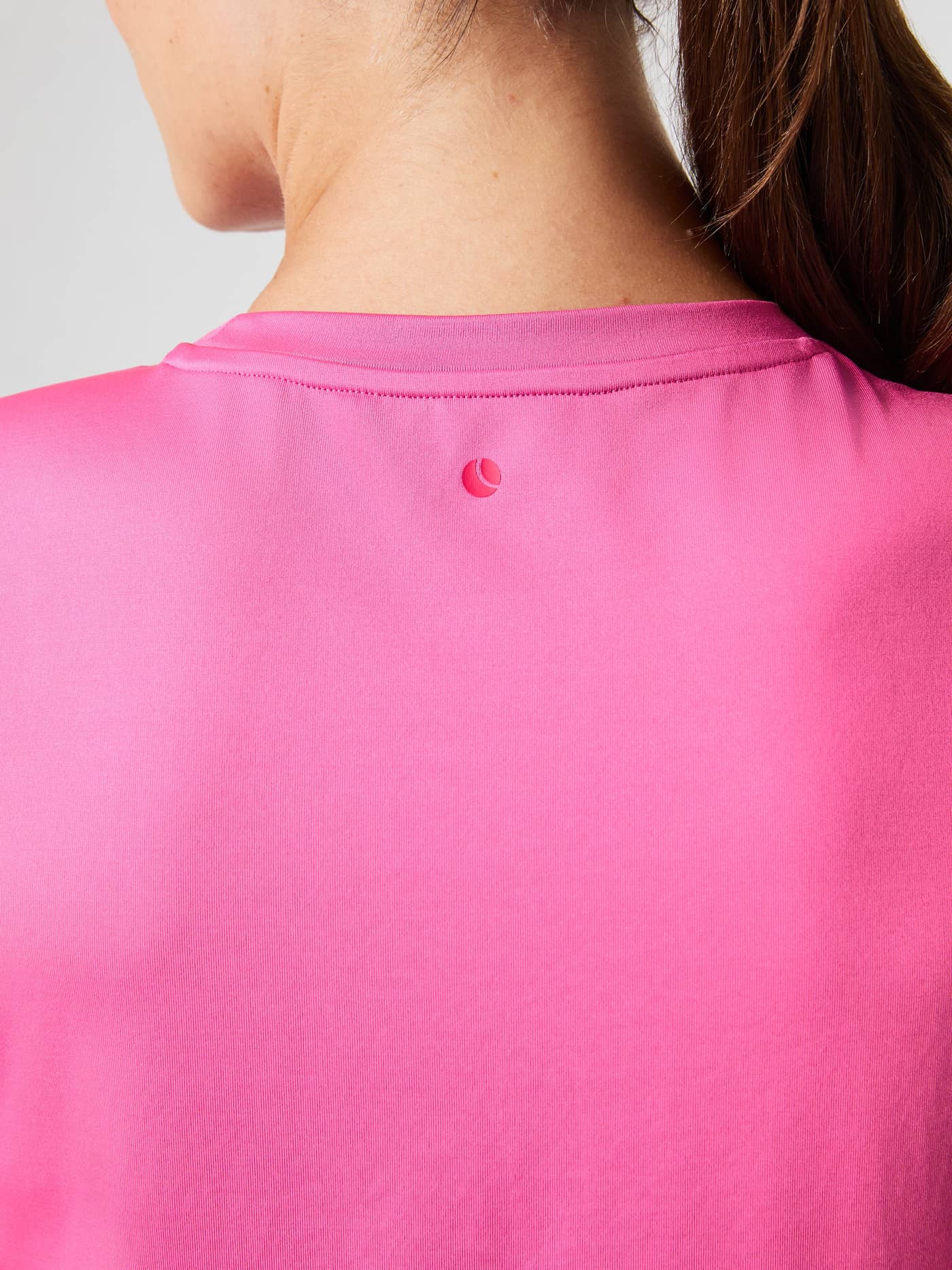 Närbild bakifrån på Borg T-Shirt i Ibis Rose (Rosa) med en rosa logotyp under halsringningen för träning. - Image 5