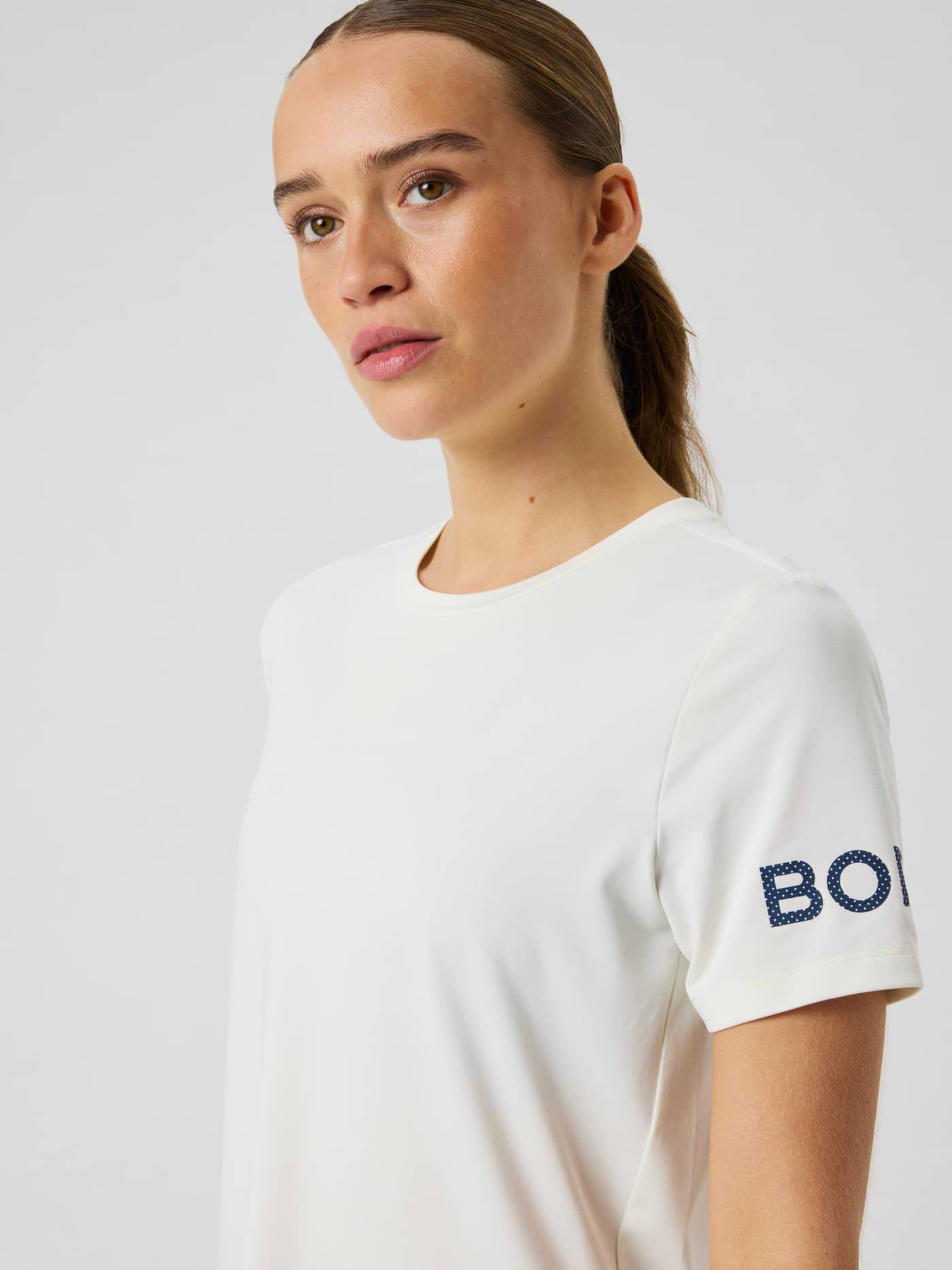 Close-up van de Borg T-Shirt in Beige (beige) met focus op de ronde hals en het armlogo. - Image 4