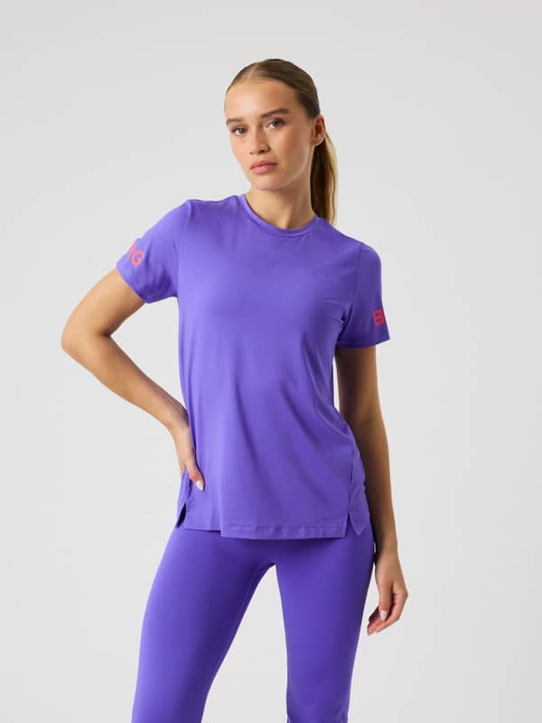 Modell framifrån i Borg T-Shirt för träning i Simply Purple (Lila) med regular fit och röda logotyper på ärmarna.