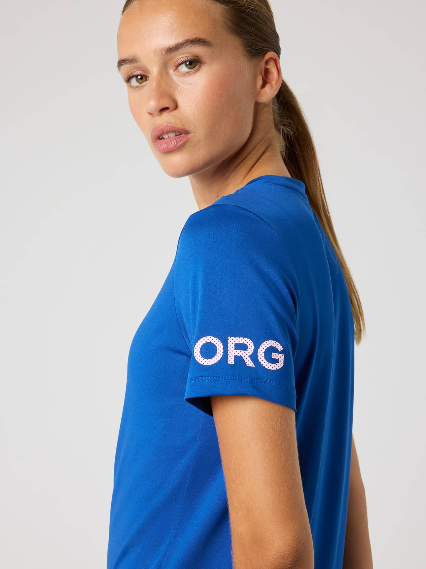 Close-up of a model in the training Borg T-Shirt in Monaco Blue (Blue), showing the white sleeve logo and regular fit. - Image 5
