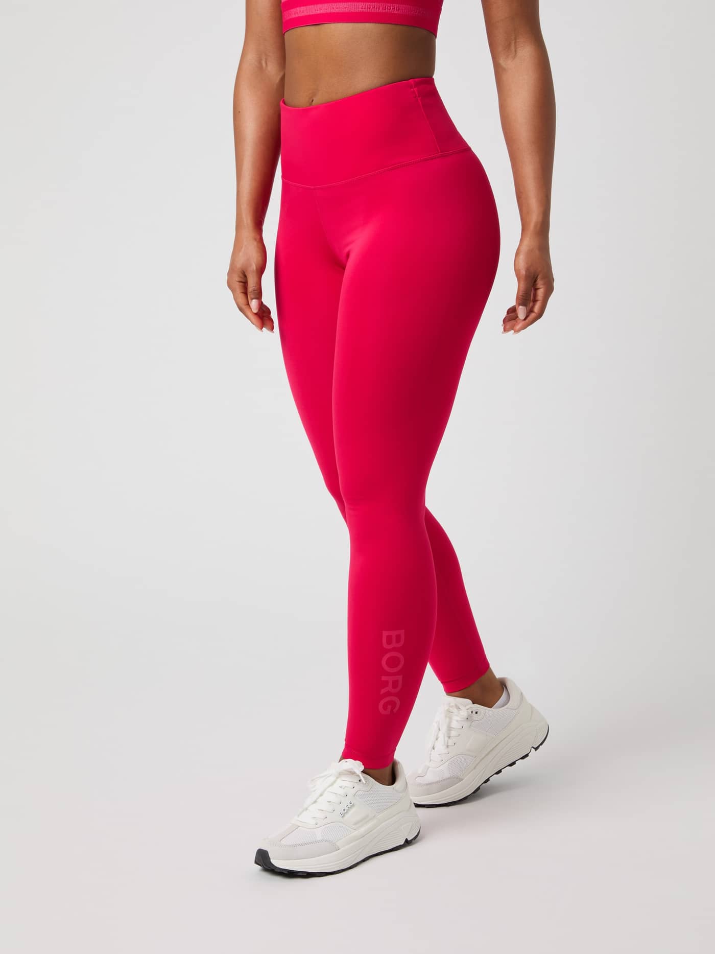 Side view of a model wearing slim-fit Borg Logo Tights in Love Potion (Pink) with a tonal logo for training. - Image 2
