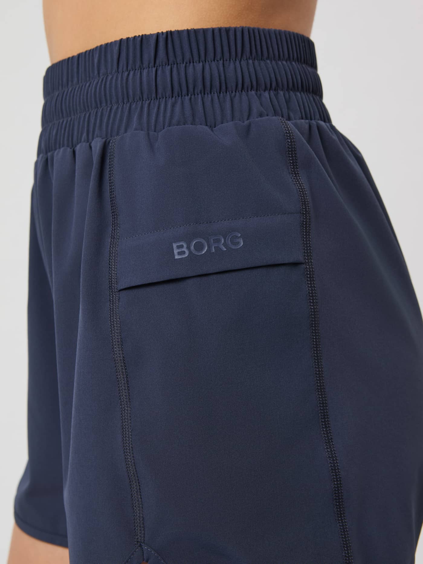 Gros plan du Borg Loose Shorts Odyssey Gray (Gris) avec poche latérale et logo ton sur ton pour l'entraînement. - Image 4