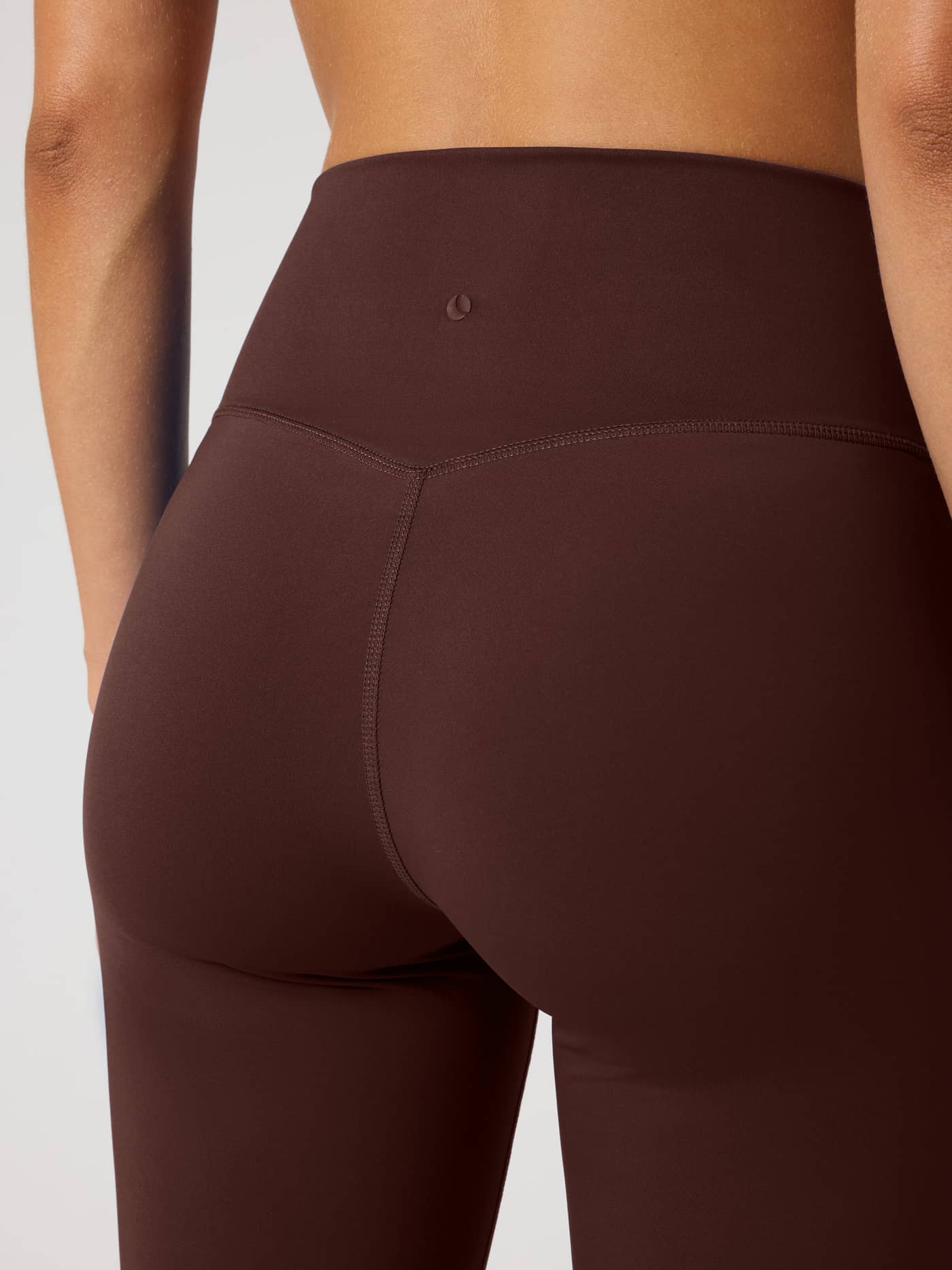 Back close-up of the Borg Flare Tights Tall in Coffee Bean (Brown) with a small tennis logo and high-waist training fit. - Image 4
