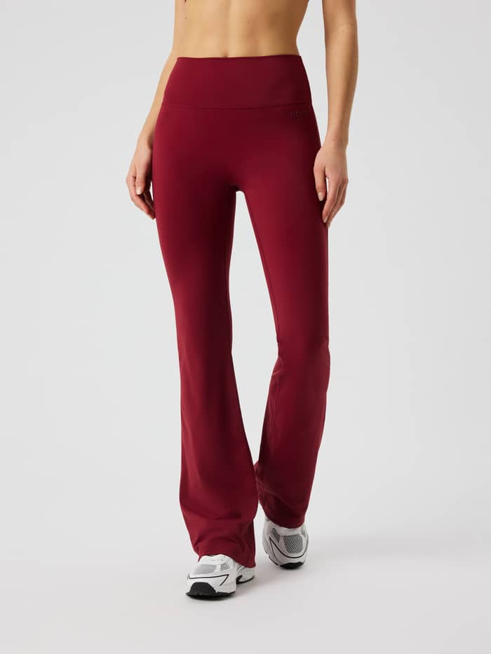 Vooraanzicht van de Borg Flare Tights Tall in Cabernet (rood) met een hoge tailleband en bootcut pijpen voor training.