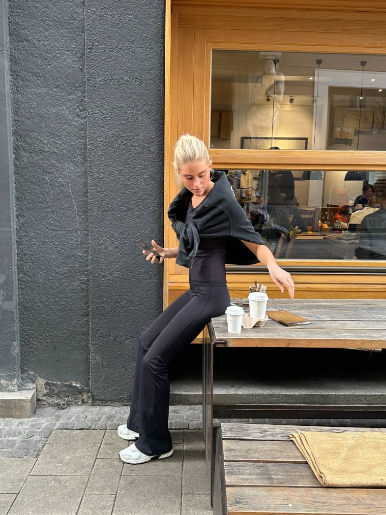 Slim-fit Borg Flare Tights Tall in Black Beauty (Black) worn by a model in an urban cafe setting, ideal for training. - Image 4