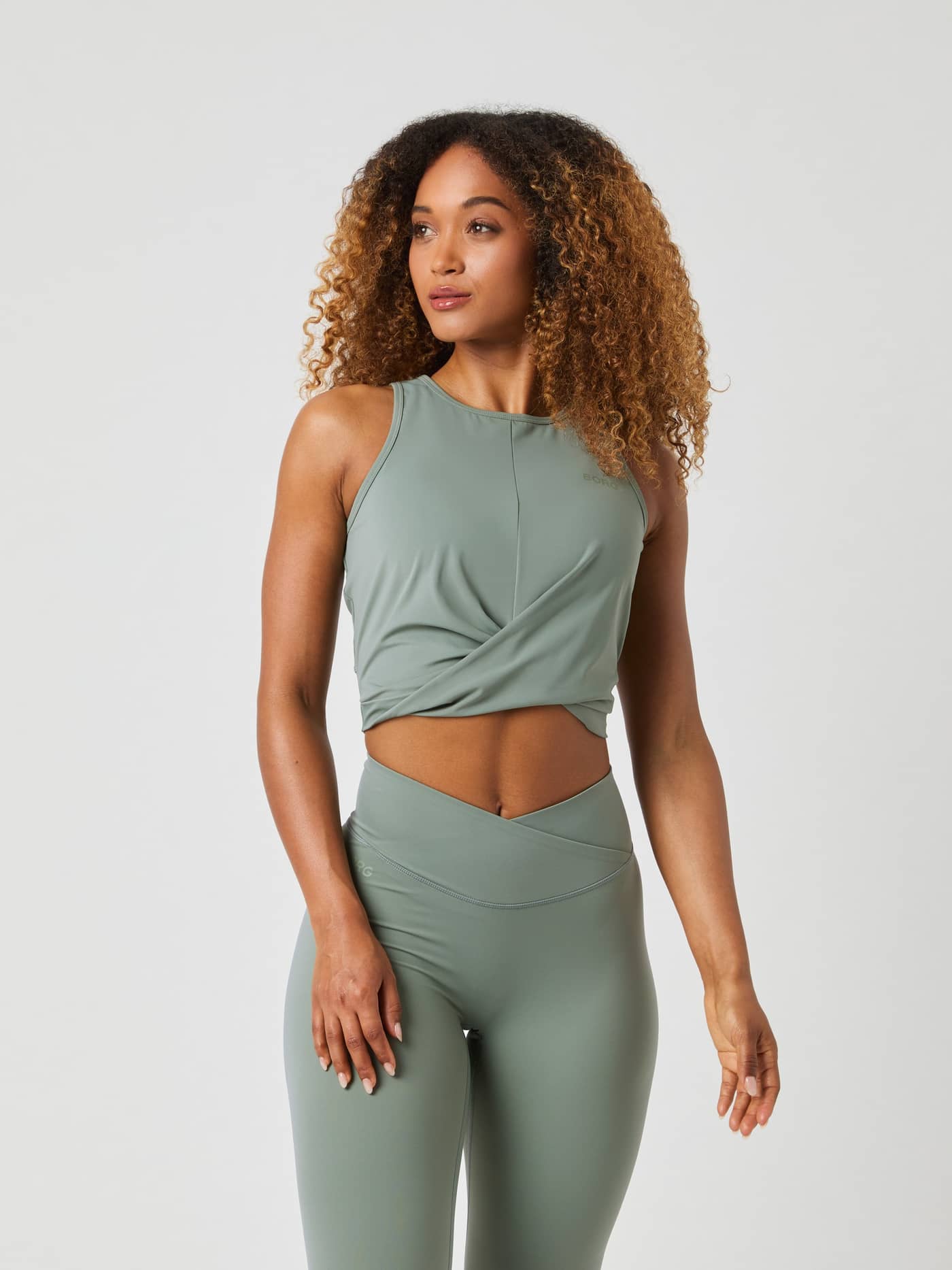 Front view of the Björn Borg Studio Cross Tank Top in Agave Green (Green) with a twisted front and tonal logo for training. - Image 1