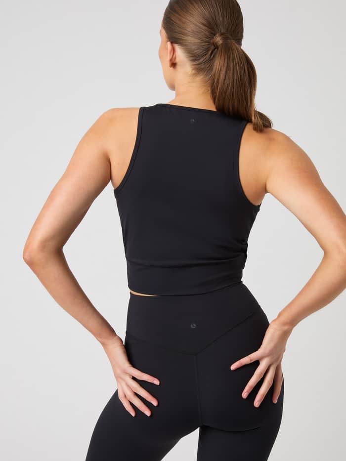 Vue arrière d'une femme portant le Studio Cross Tank Top en Black Beauty (Noir) pour une tenue d'entraînement stylée. - Image 2