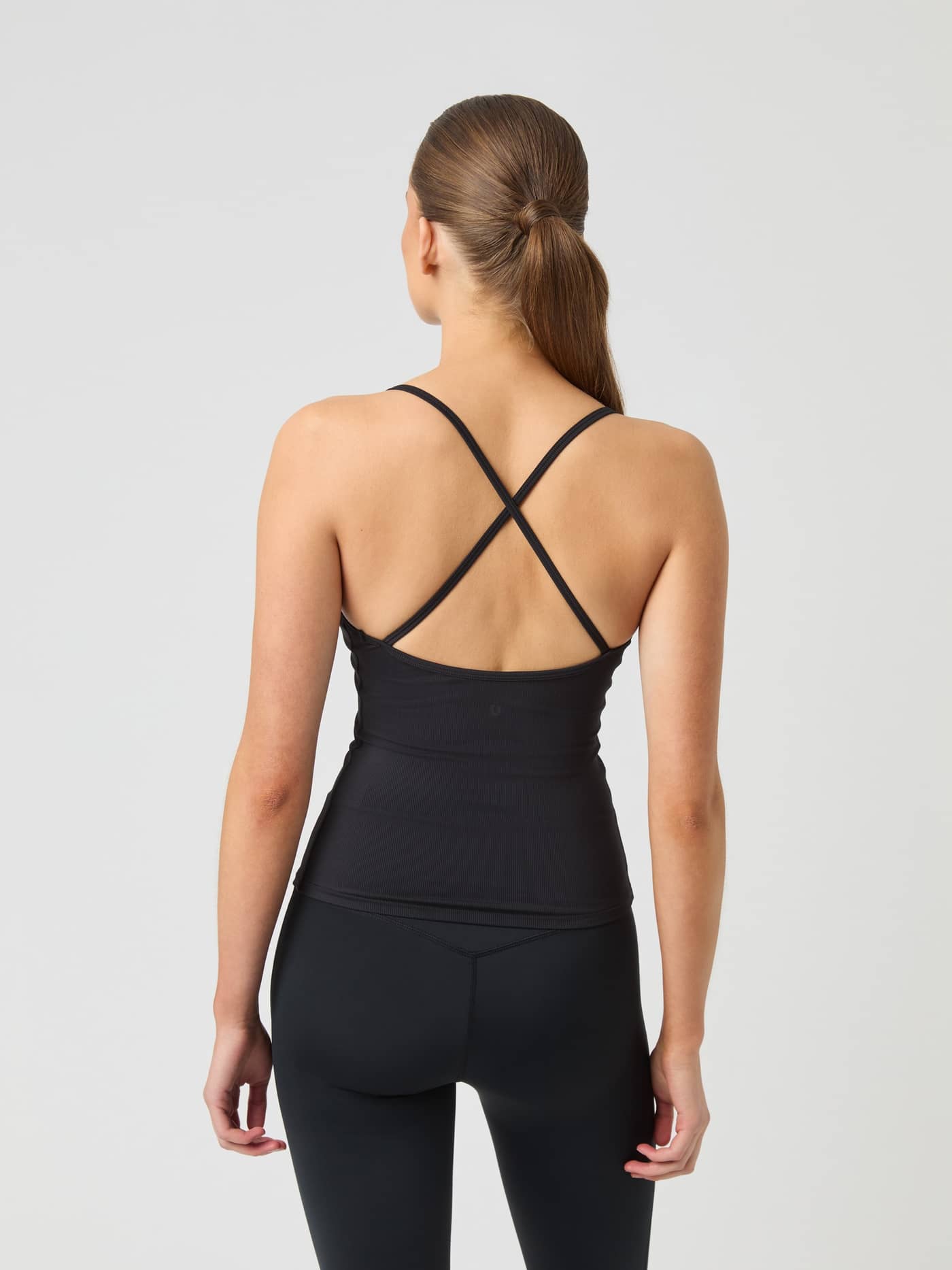 Modell sedd bakifrån i Björn Borg Studio Ribbed Strap Tank Top i Black Beauty (Svart) med korslagda band för träning. - Image 3