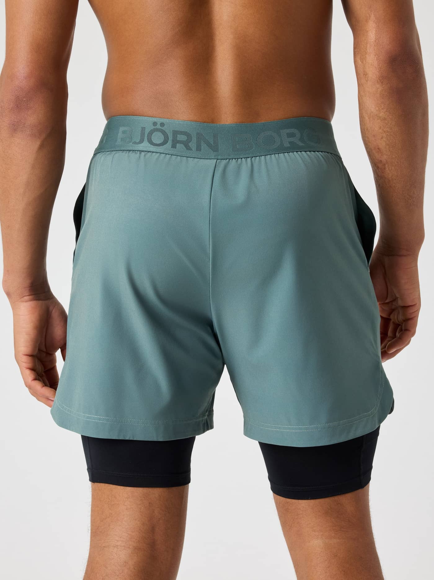 Vue de dos d'un homme en Borg 2 In 1 Shorts Balsam Green (Vert) avec taille griffée pour le tennis et l'entraînement. - Image 2