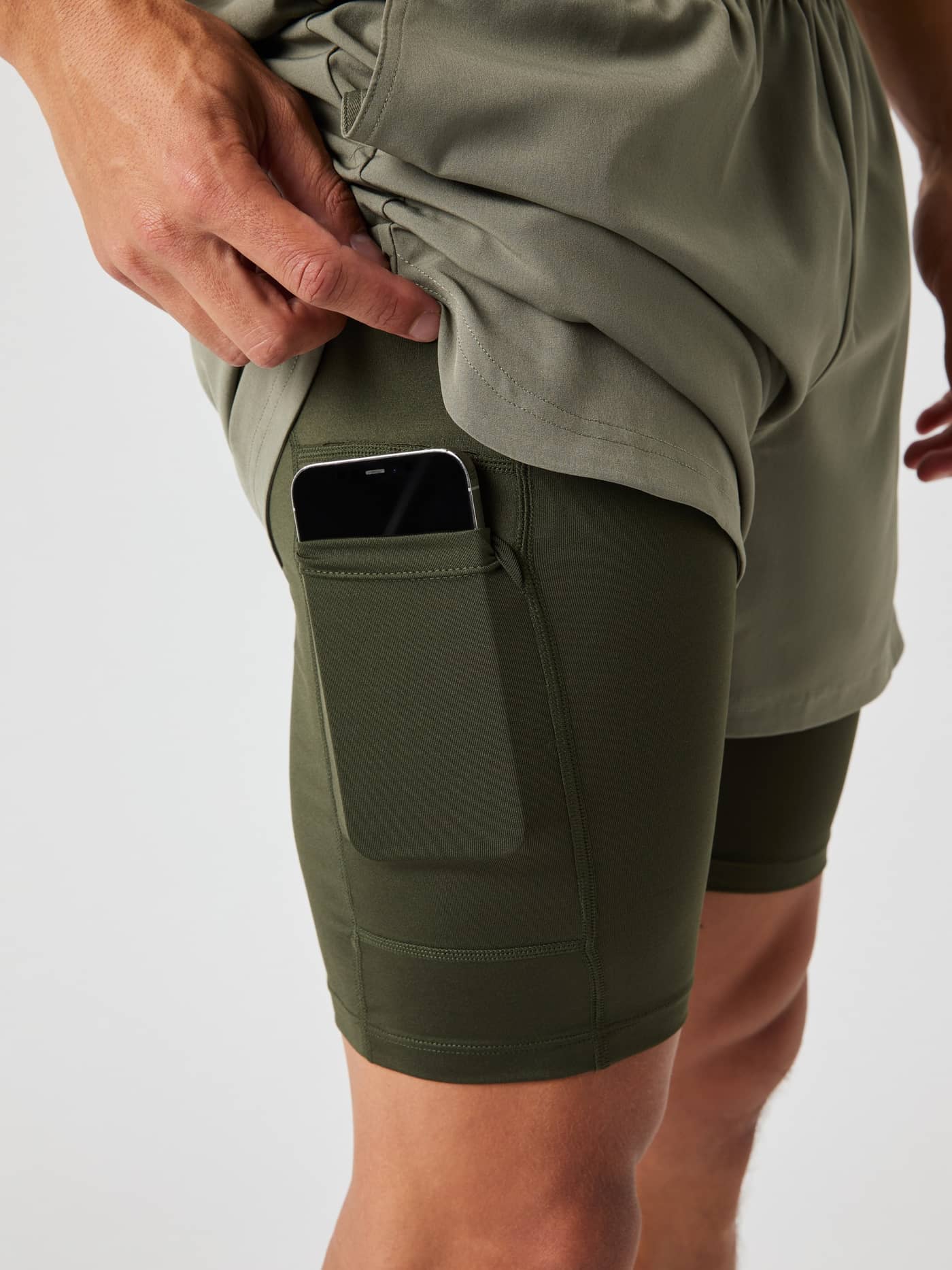 Primer plano del bolsillo para móvil en los Borg 2 In 1 Shorts en Dusty Olive (Verde) para entrenamiento de hombre. - Image 4