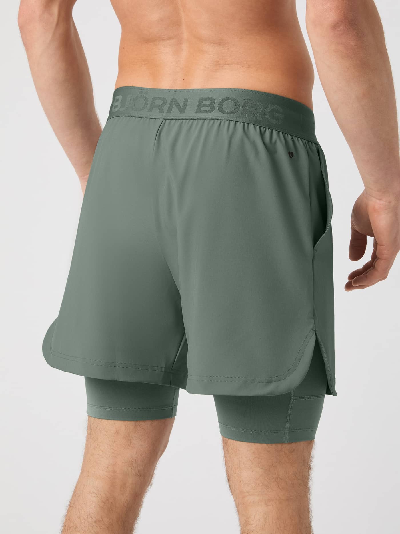 Back view of a man wearing the stylish Borg 2 In 1 Shorts in Agave Green (Green) with a tonal logo for performance training. - Image 2