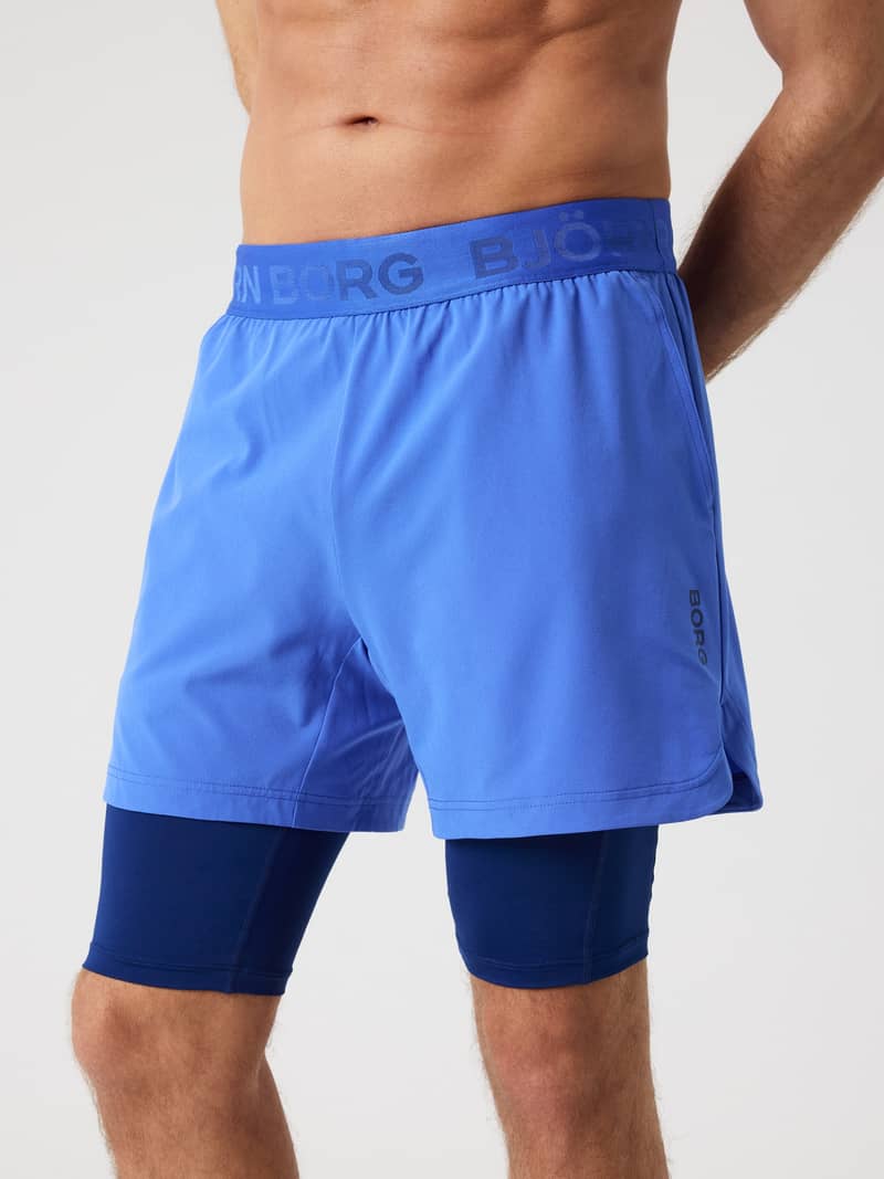 Vista frontal de los Borg 2 In 1 Shorts en Amparo Blue (Azul) para entrenamiento con logo oscuro y cintura de marca.