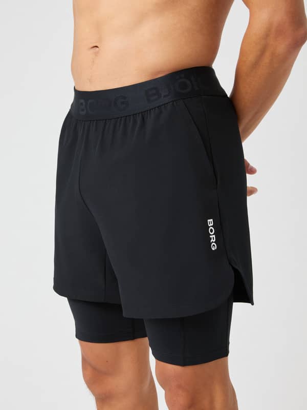 Close-up side view of a man wearing the Borg 2 In 1 Shorts in Black Beauty (Black) for performance training.