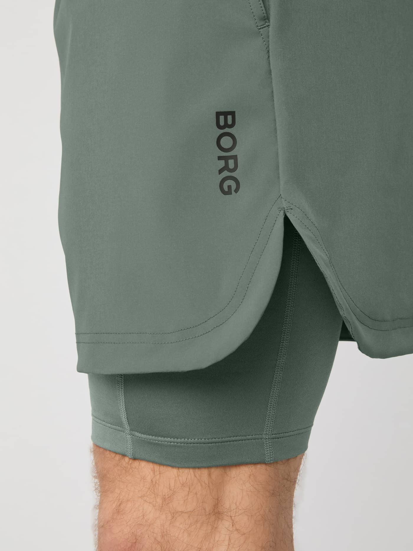Side close-up of the Borg 2 In 1 Shorts in Agave Green (Green) showing the black logo and functional training side slit. - Image 4