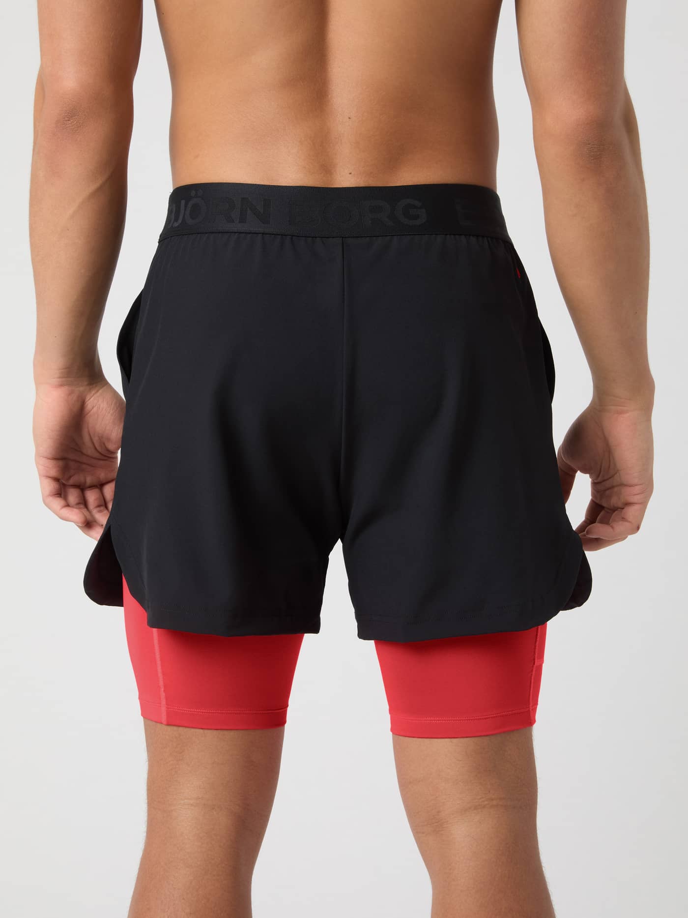 Back view of Borg 2 In 1 Shorts in Black Beauty (Black) for training, featuring red inner shorts and a black logo. - Image 2