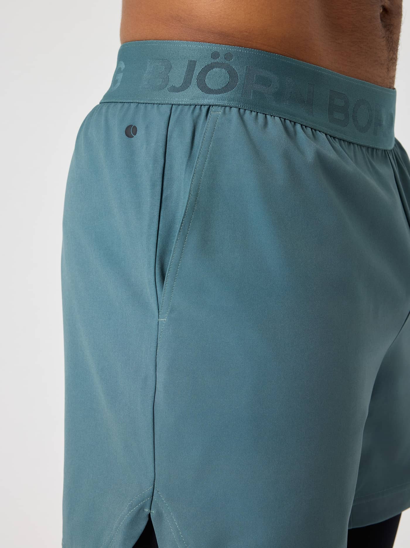 Vue de profil du Borg 2 In 1 Shorts en Balsam Green (Vert) avec ceinture logotée pour le tennis et l'entraînement. - Image 3