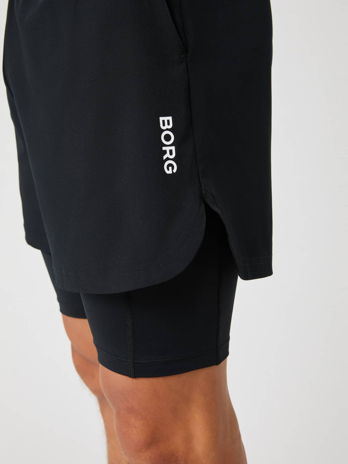 Seitenansicht der Borg 2 In 1 Shorts in Black Beauty (Schwarz) für Herren mit weißem Logo und Schlitzen für das Training. - Image 4
