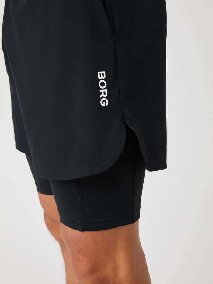 Seitenansicht der Borg 2 In 1 Shorts in Black Beauty (Schwarz) für Herren mit weißem Logo und Schlitzen für das Training. - Image 4
