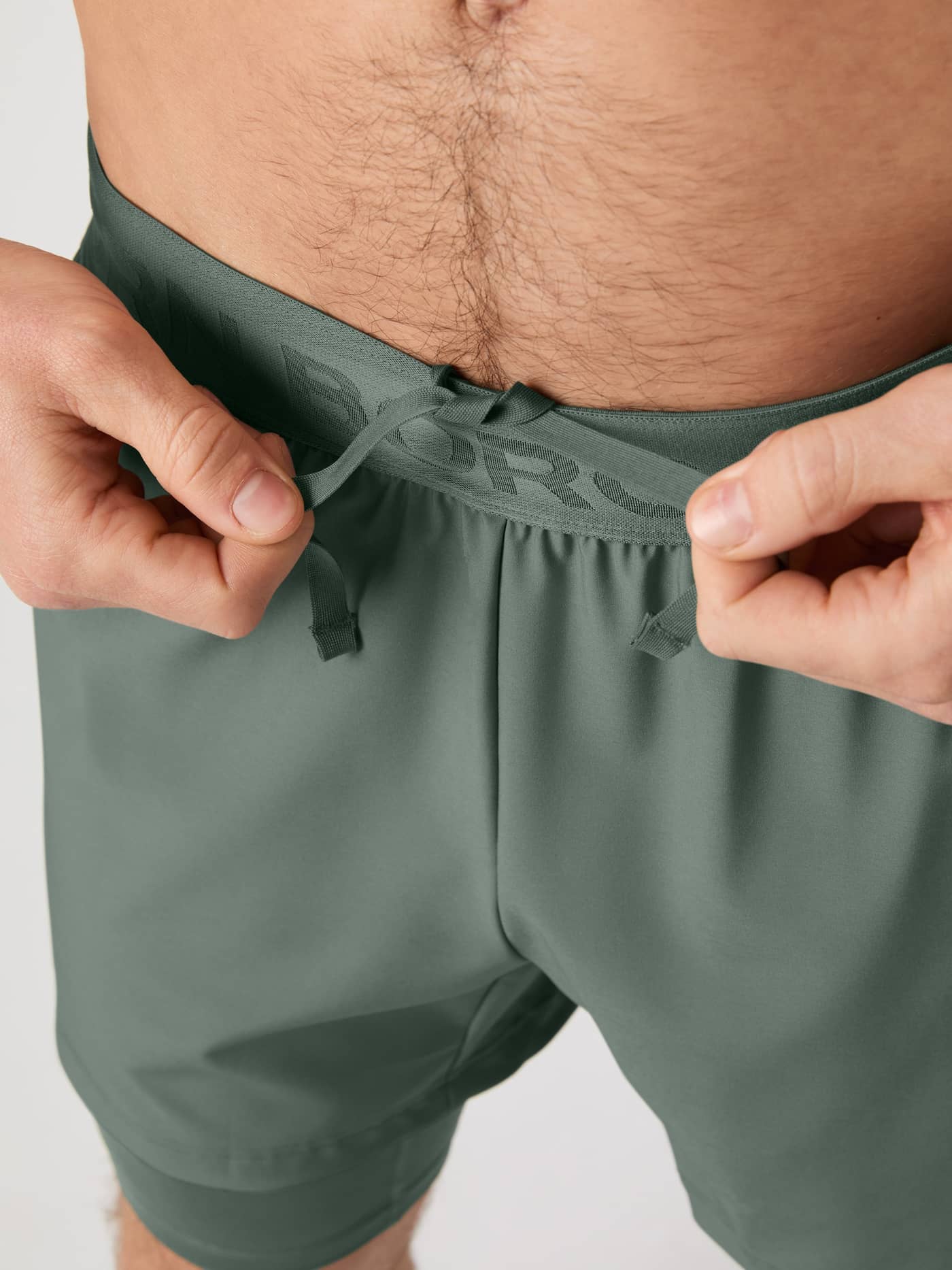 Close up of the adjustable drawstring on the Borg 2 In 1 Shorts in Agave Green (Green) for performance training. - Image 5
