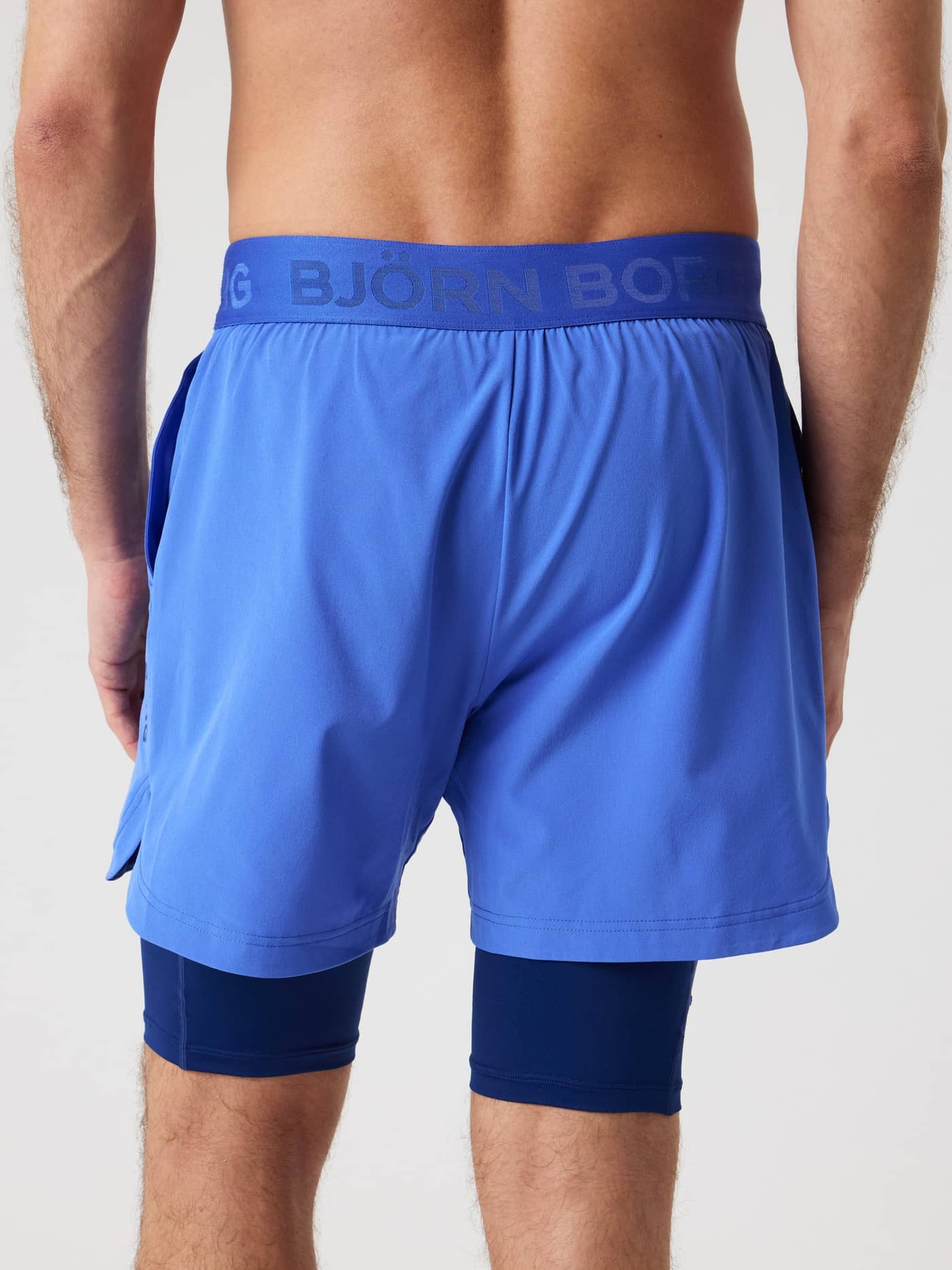 Vista posterior de los Borg 2 In 1 Shorts en Amparo Blue (Azul) de entrenamiento con logo azul y pantalón interior. - Image 2