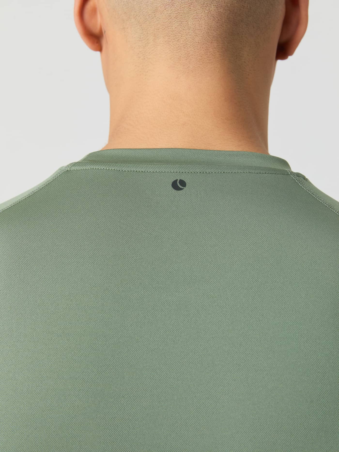 Close-up of the back of a model wearing the Borg Athletic T-shirt in Agave Green, showing the logo detail on the neck. - Image 5