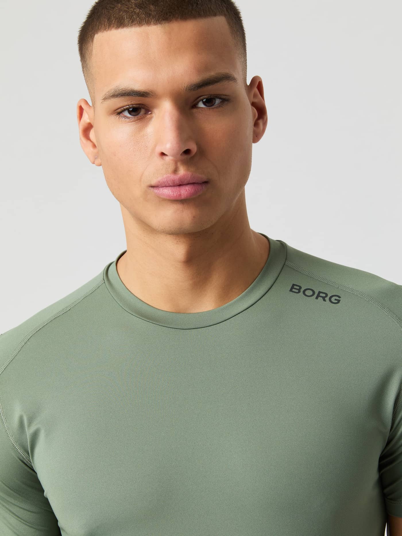 Close-up of a man wearing the Borg Athletic T-shirt in Agave Green, showing the neckline and logo detail. - Image 4