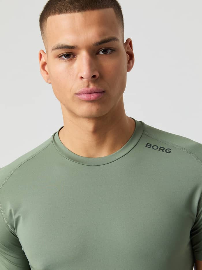 Close-up of a man wearing the Borg Athletic T-shirt in Agave Green, showing the neckline and logo detail.