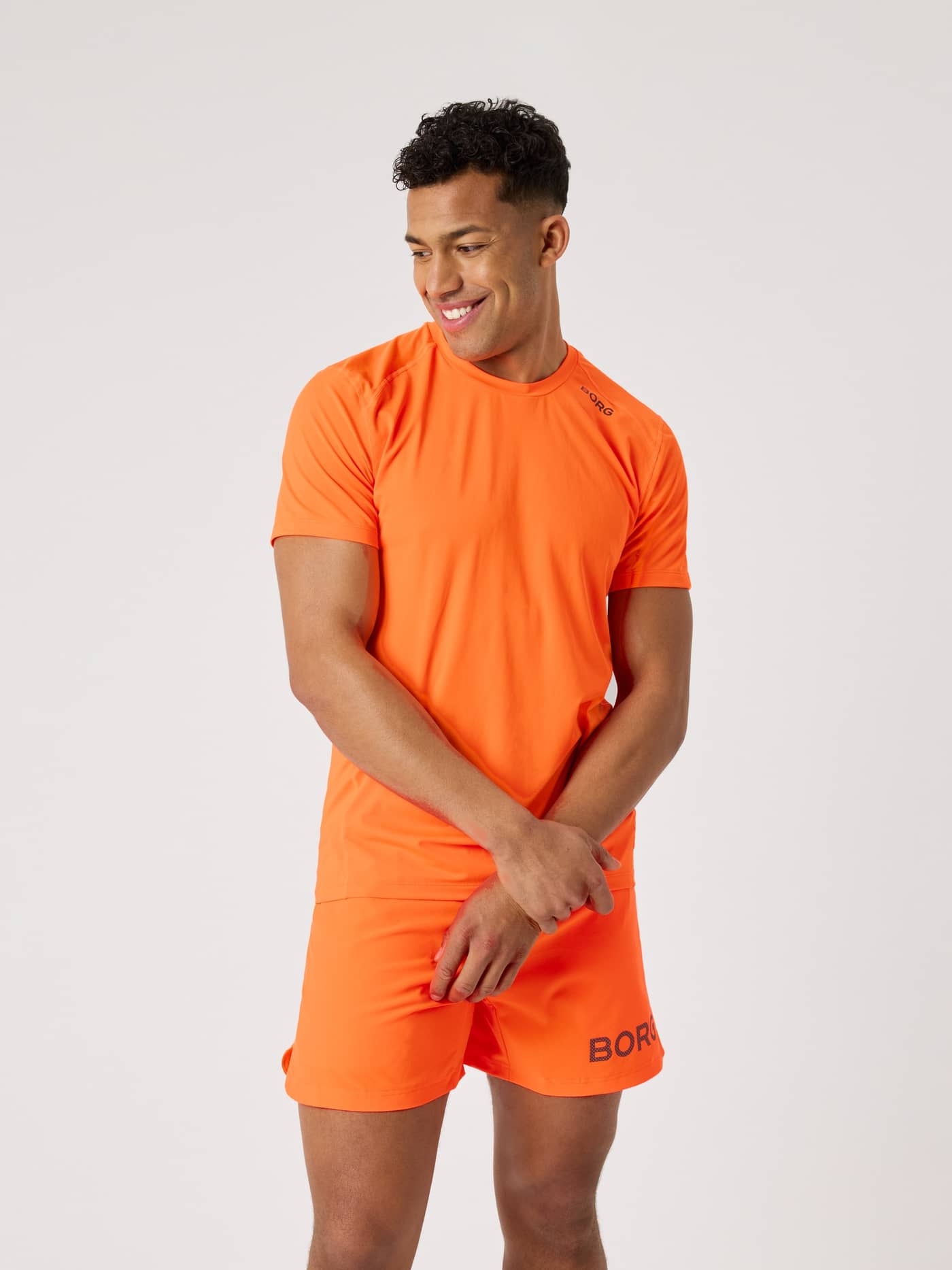 Front view of a man wearing the Borg Athletic T-Shirt in Shocking Orange (Orange), a functional training top. - Image 2