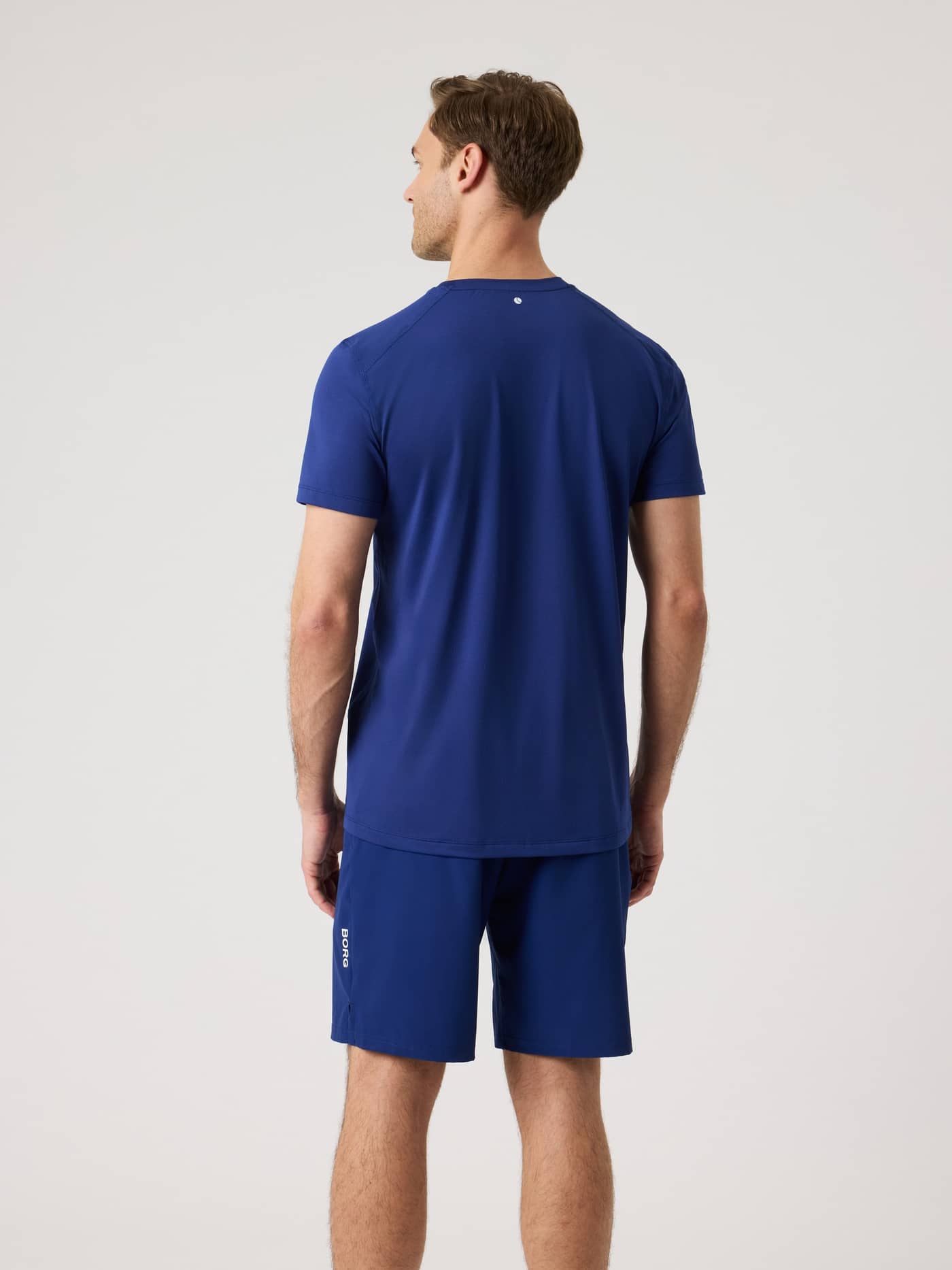 Vue de dos d'un homme portant le Borg Athletic T-Shirt en Blue Depths (Bleu), un haut respirant pour l'entraînement. - Image 2