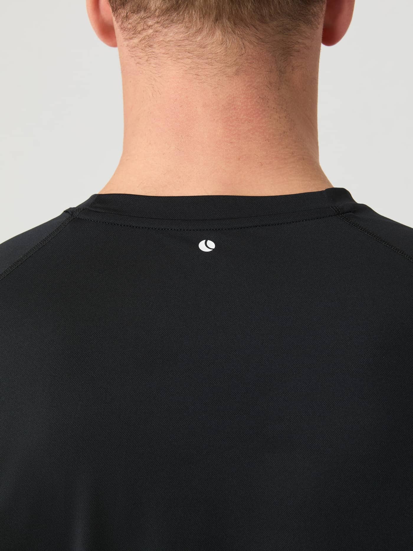 Close-up on the back of the neck of the black Borg Athletic T-Shirt showing the small logo detail. - Image 5