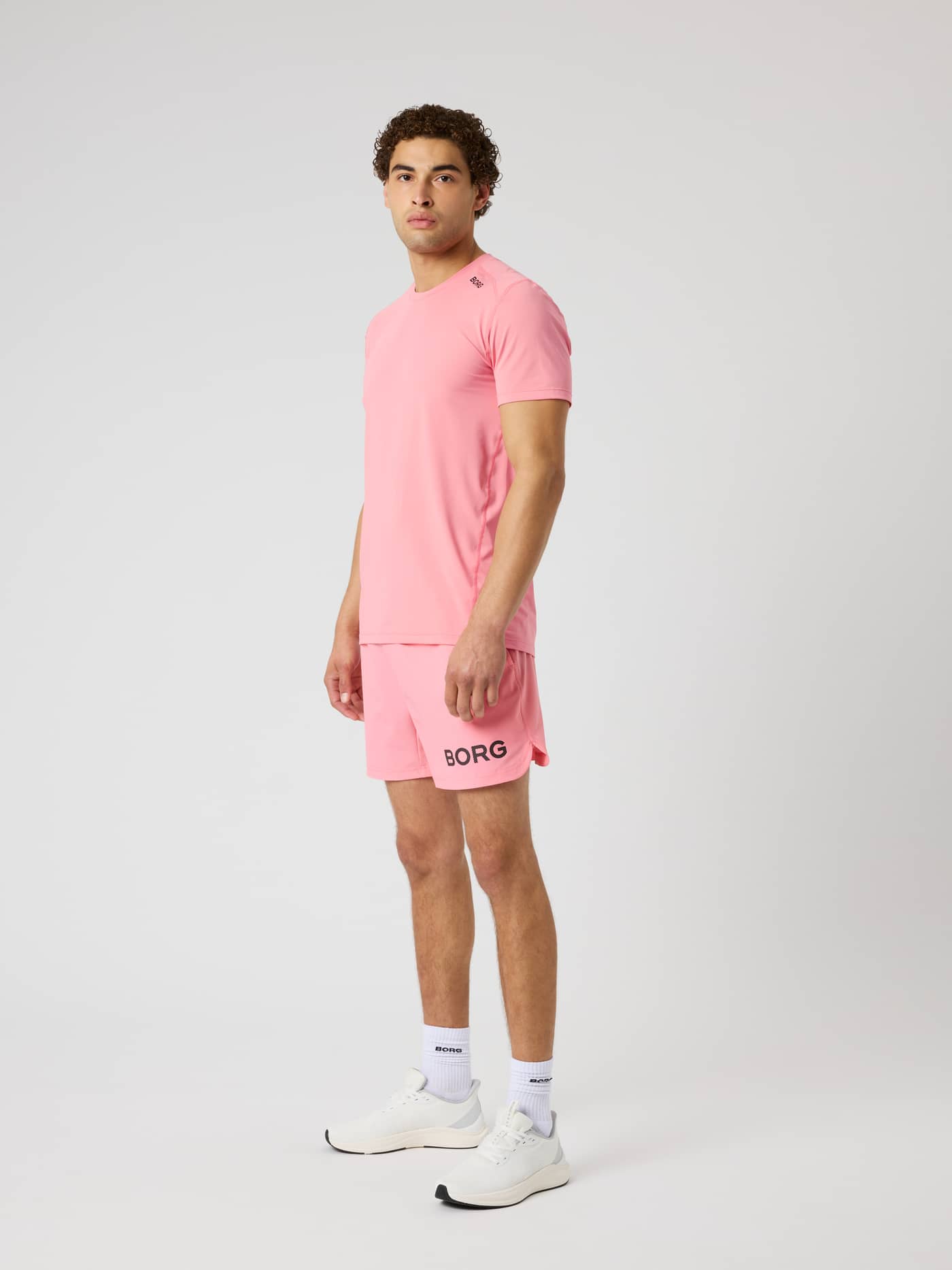 Side profile of a model wearing the Borg Athletic T-Shirt in Strawberry Ice (Pink) for functional training sessions. - Image 3