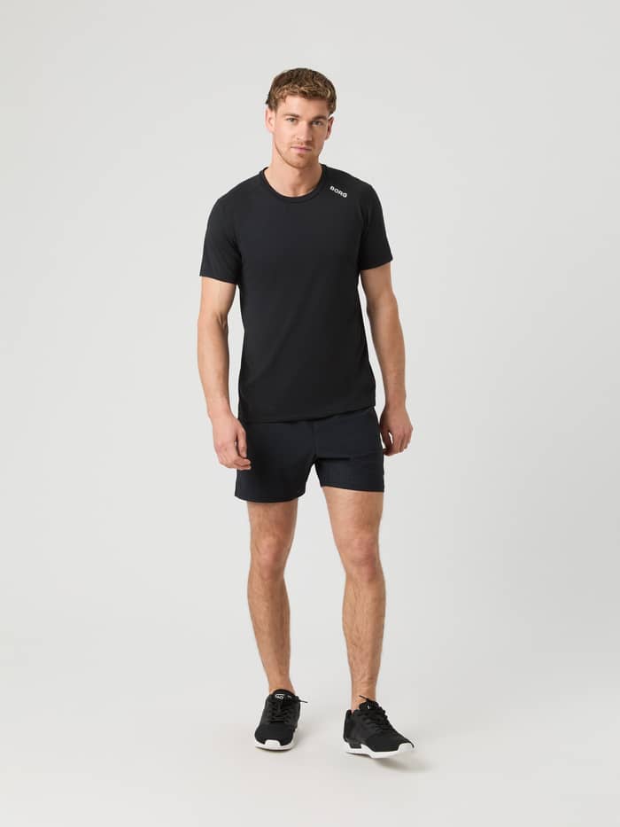 Man in het Borg Athletic T-Shirt in Black Beauty (Zwart) met zwarte short, ideaal voor performance en training. - Image 3