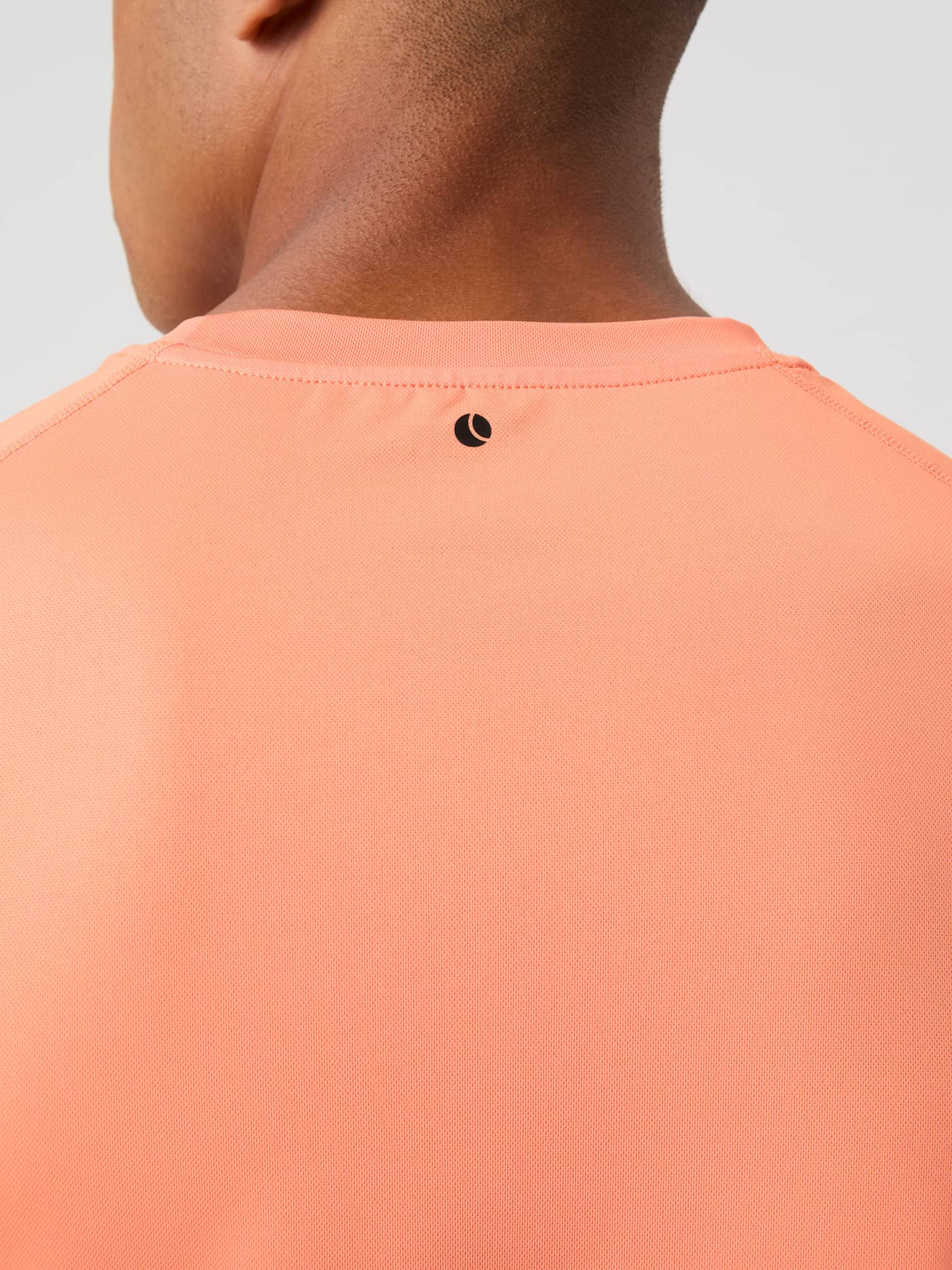 Närbild på en svart logotyp i nacken på Borg Athletic T-Shirt i Papaya (Orange) för herrar och träning. - Image 4