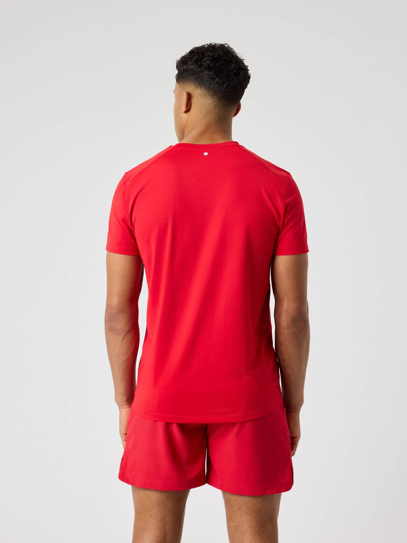 Back view of a man wearing the Borg Athletic T-Shirt in Lychee (Red), designed for high-performance training. - Image 2
