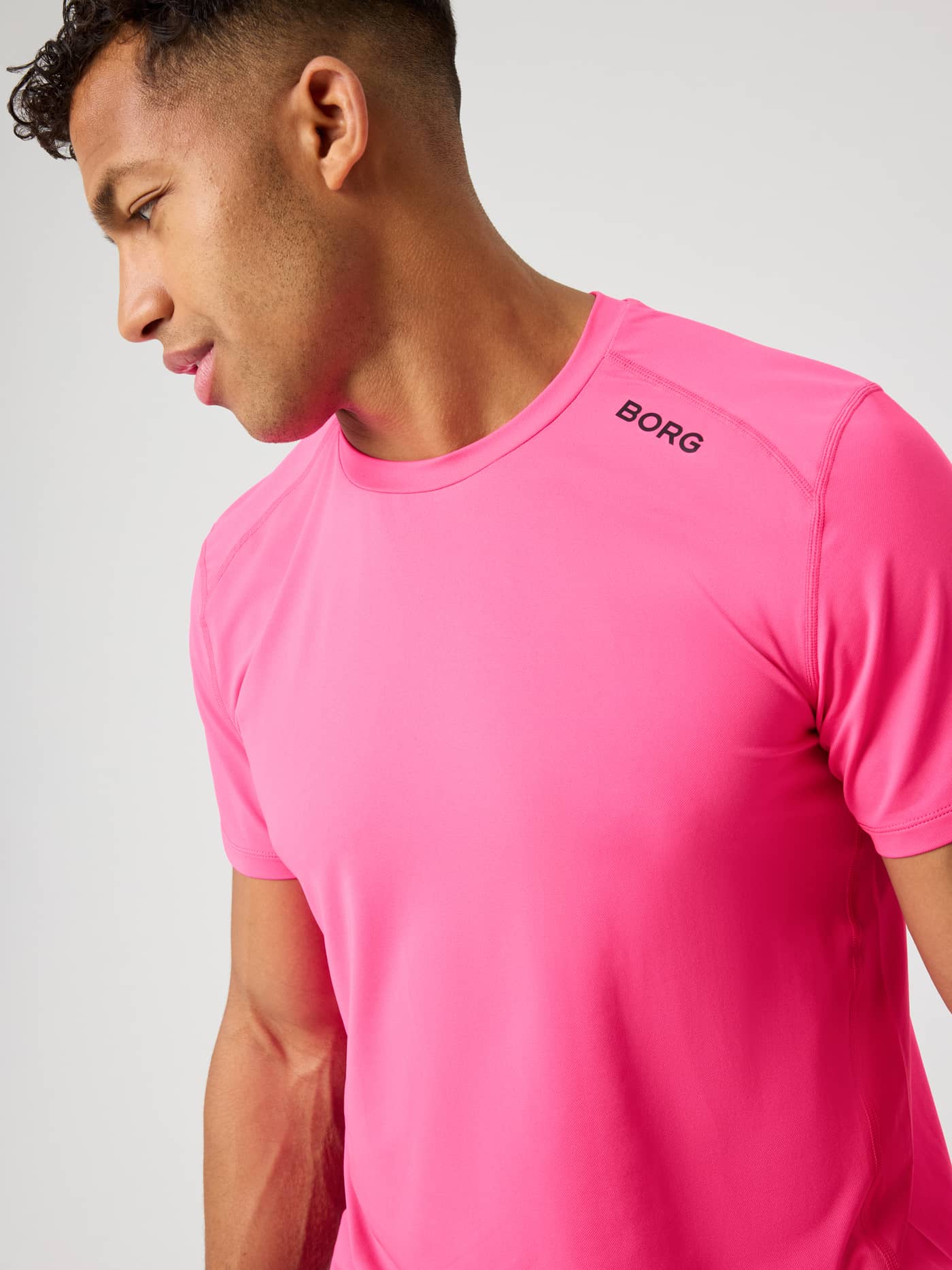 Borg Athletic T-Shirt i Pink Glo (Pink) set i nærbillede med sort skulderlogo til performance og træning. - Image 5
